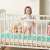 Ricokids mint green braided crib bumper in a crib with a baby