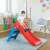 Child playing on Dolu My First Slide red plastic slide for kids with blue ladder in a room