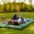Couple relaxing on Timeless Tools double inflatable camping mat in green