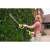 Woman using Ryobi OHT1850X cordless hedge trimmer to trim a hedge