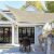 Beige shade sail installed over patio dining area