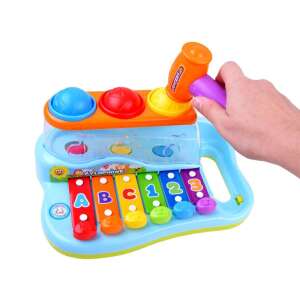 Child playing with a colorful interactive xylophone toy with a hammer and balls - Toy Instrument