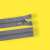 Gray zipper with metal slider, 50 cm long, on yellow background