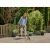 Woman using Gardena EasyWeed cordless joint cleaner on patio