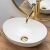Elegant Rea Sofia oval washbasin with gold trim and faucet
