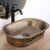 Angled view of REA WILMA RUSTIC bronze oval countertop washbasin
