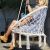 Woman sitting in Springos macrame hanging chair on patio