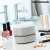 InnovaGoods Mini Tischstaubsauger Micuum Gadget Tech, weiß, auf einem Tisch mit Make-up-Produkten