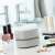 InnovaGoods Mini Tischstaubsauger Micuum Gadget Tech, weiß, auf einem Tisch mit Make-up-Produkten
