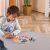 Toddler playing with Viga PolarB wooden shape sorting clock.
