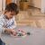 Child playing with Viga PolarB wooden shape sorting clock on a table.