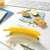Snips Banana Guard, yellow plastic banana storage container, keeps bananas fresh, in use