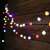 Solar powered string lights with 50 colorful bulbs, hanging on a wooden wall