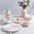 Ambition Magnolia porcelán étkészlet tányérokkal, bögrékkel és tálakkal, virágmintás díszítéssel.
