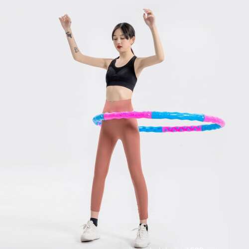 Woman using a blue and pink weighted hula hoop for exercise