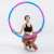 Woman holding a blue and pink weighted hula hoop