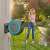 Woman using Gardena PowerRoll XL automatic hose reel to water plants in her garden