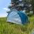 Pop-up beach tent, blue and white, set up in a grassy field