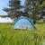 Pop-up beach tent, blue and white, set up in a grassy field