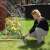 Woman using 360 degree rotating sprinkler with adjustable nozzles to water flowers in her garden