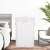 White bamboo laundry hamper in a bedroom setting