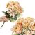 Two Springos decorative peach rose bouquets, one held in hand