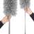 Two hands holding Springos telescopic dust brush, gray