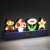 Paladone Super Mario Bros. Icons Light, a 30cm wide lamp featuring Mario, a mushroom, a flower, and a star, lit up