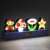 Paladone Super Mario Bros. Icons Light, a 30cm wide lamp featuring Mario, a mushroom, a flower, and a star, lit up