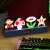 Paladone Super Mario Bros. Icons Light, a 30cm wide lamp featuring Mario, a mushroom, a flower, and a star, on a desk