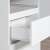 A fehér sarok íróasztal fiókjának közeli képe, amelyen látható a fém görgős csúszka