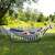 Woman relaxing in a Springos double hammock with a stand, in a garden setting