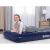 Woman relaxing on Bestway inflatable guest bed indoors