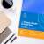 Bluering L-kształtny ochraniacz na arkusze, format A4, 25 sztuk, 80 mikronów, niebieski przezroczysty, na biurku z filiżanką kawy i długopisem