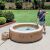 Man cleaning an Intex inflatable hot tub with the Intex 28626 cordless pool vacuum