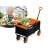 Humberg HM-513 folding wagon, black with orange accents, loaded with vegetables, man in the background