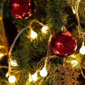 Weihnachtsbaum mit roten Kugeln und weißen Lichterketten geschmückt - Christbaumschmuck