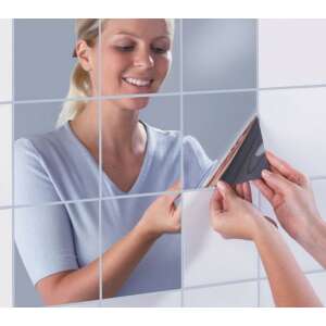 Woman applying silver mirror tiles to wall - Furniture