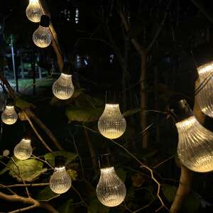 Solar powered LED string lights with 20 bulbs, warm white light, Stripes model, hanging on a tree branch at night - GardenLine