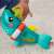 Baba játszik a Fisher-Price Paradise Pals Busy Activity Shark játékkal, a cápa farka közeli képe