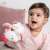Baby playing with Fehn Unicorn Rattle, a soft plush toy with a rattling ring and colorful beads