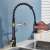 Blackswan M102 kitchen faucet, black and gold, 44 cm, installed in a kitchen sink, hand is shown using the faucet