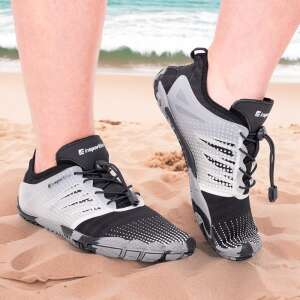 inSPORTline Solaric vízi cipők, amelyeket egy személy visel egy homokos strandon, bemutatva a fekete és szürke színt, valamint a gyorsan oldható fűzőrendszert - Vízicipő