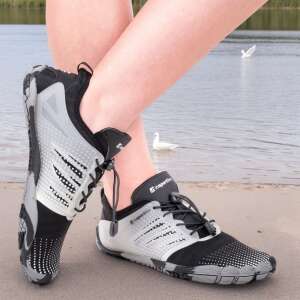 Az inSPORTline Solaric vízi cipőket egy személy viseli egy homokos strandon a víz közelében, fekete és szürke színben - Vízicipő