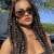 Woman with long brown braids, wearing sunglasses and a black top, showcasing Soulima synthetic hair braids