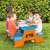 Children playing at a Hot Wheels picnic table, blue and orange plastic table with benches, perfect for outdoor play