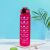 Magenta motivational water bottle with time markers on a table