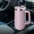 Pink 1200 ml stainless steel travel mug with handle and straw in a car cup holder