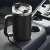 Black 1200ml stainless steel travel mug with handle and lid, in a car cup holder