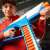 Човек държи Nerf N-Series Infinite Blaster, син, бял, оранжев, снимка на действие
